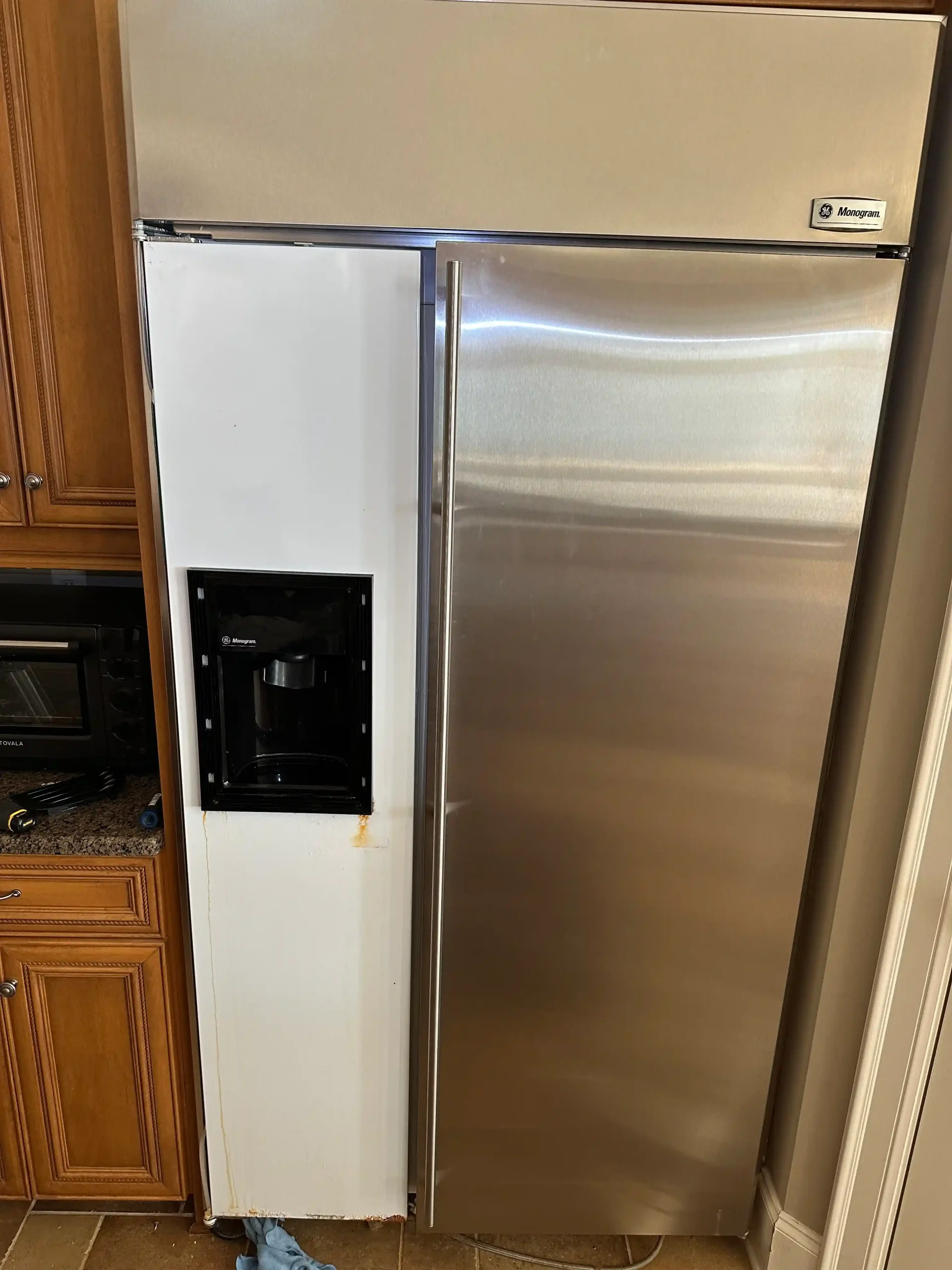 Built-in stainless steel refrigerator in a Charlotte kitchen, showing the appliance in place before deciding whether to repair or replace it.