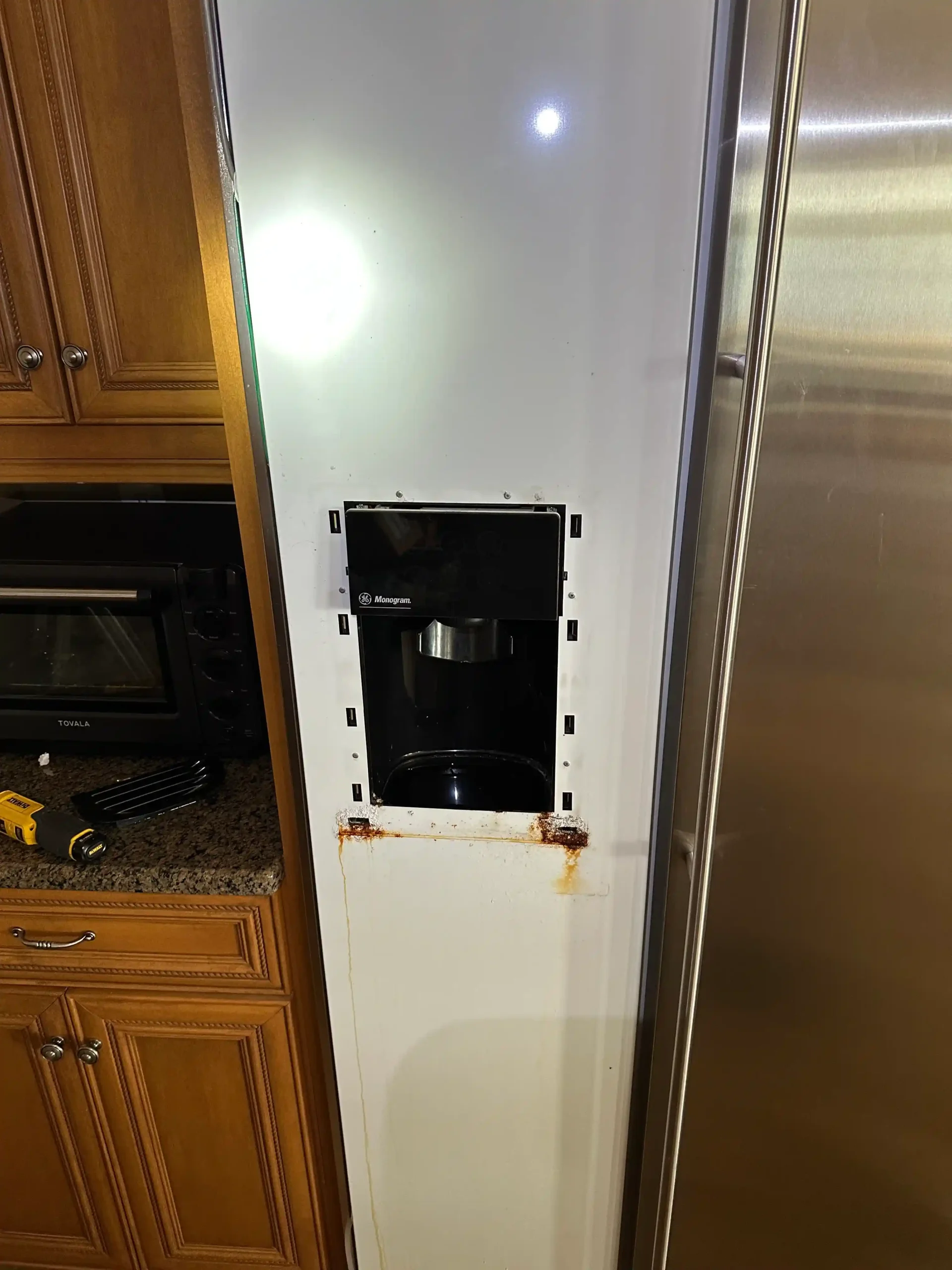 Refrigerator service access panel removed to inspect internal components during a repair diagnosis.